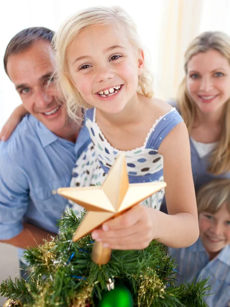 Otec zvedání svou dceru dát vánoční hvězdou na vrcholu — Stock fotografie