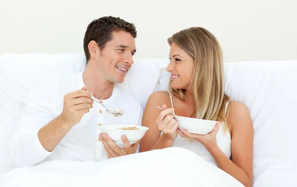 Milující pár snídáš ležící na posteli — Stock fotografie