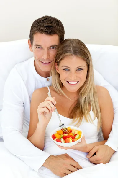 愛情のあるカップルの彼らのベッドに横たわっている果物を食べて — ストック写真