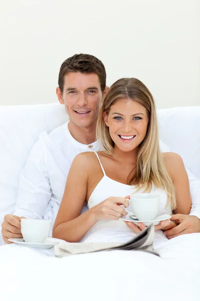 Ρομαντικό ζευγάρι πίνοντας καφέ ξαπλωμένος στο κρεβάτι τους — Φωτογραφία Αρχείου
