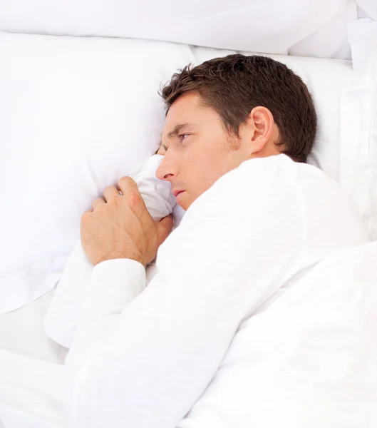 Retrato de un hombre triste acostado en la cama — Foto de Stock