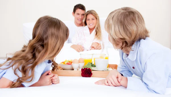 Família caucasiana tomando café da manhã sentado na cama — Fotografia de Stock
