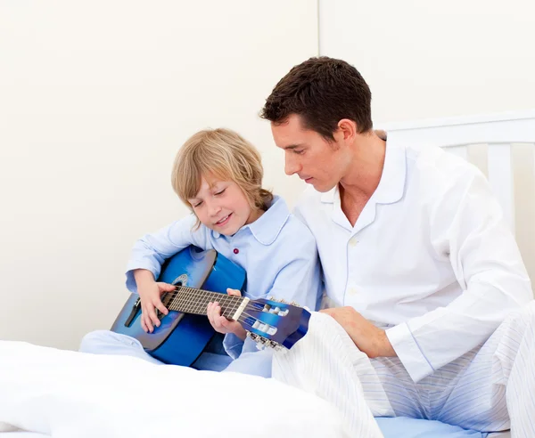 Adorable little boy playing guitar with his father — Stock Photo, Image