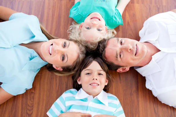 Lachende familie liggen in cirkel op de verdieping — Stockfoto