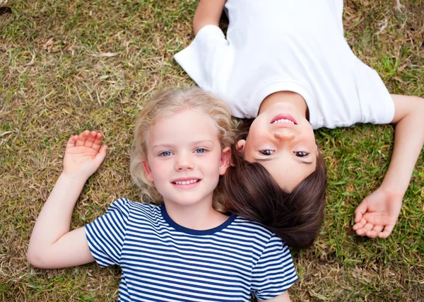 Rozkošný sourozenci ležící na trávě — Stock fotografie