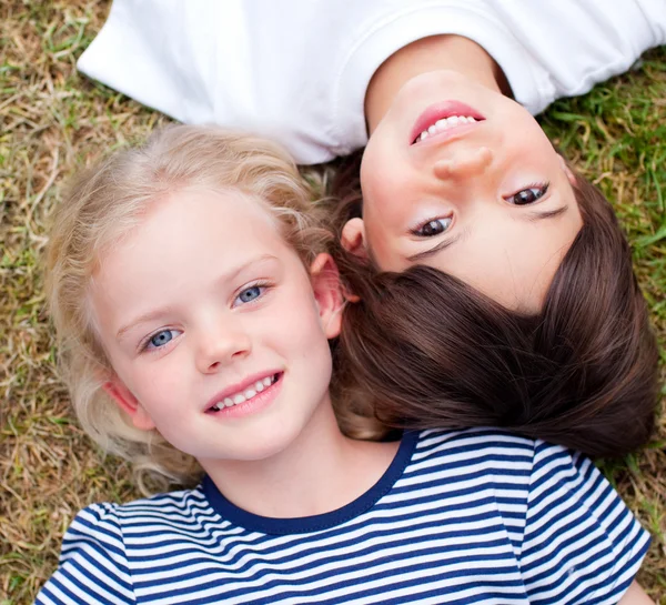Close-up of cute siblings lying on the grass — Stock Photo, Image