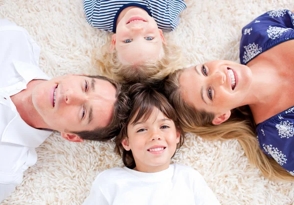 Famiglia allegra sdraiata in cerchio sul tappeto da parete a parete — Foto Stock
