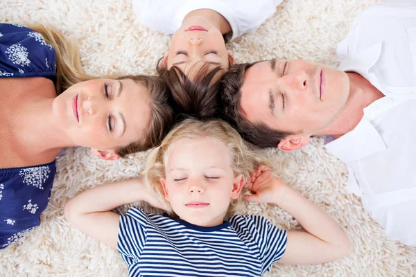 Famiglia rilassata sdraiata in cerchio sul tappeto da parete a parete — Foto Stock