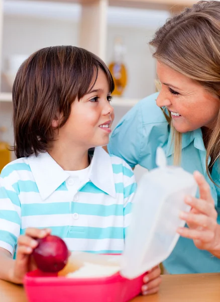Joyful little boy and his mother preparing his snack — Stock Photo, Image