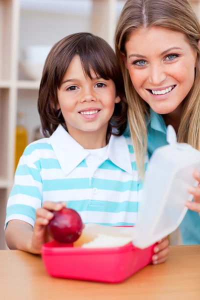 Cheerful little boy and his mother preparing his snack — Stock Photo, Image