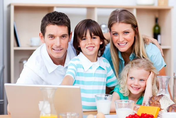 Famille aimante en utilisant un ordinateur portable pendant le petit déjeuner — Photo