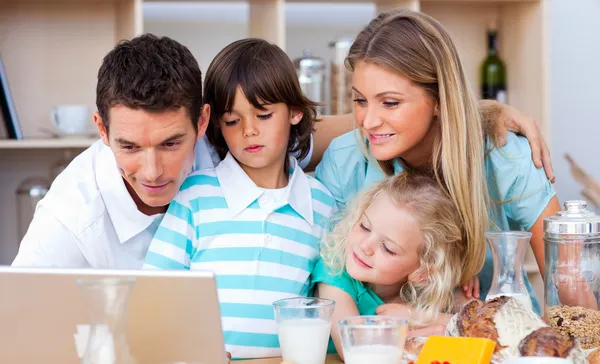 可爱的家庭在早餐期间使用便携式计算机 — 图库照片