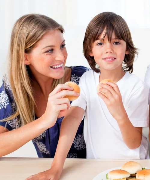 Mãe atraente e seu filho comendo hambúrgueres — Fotografia de Stock