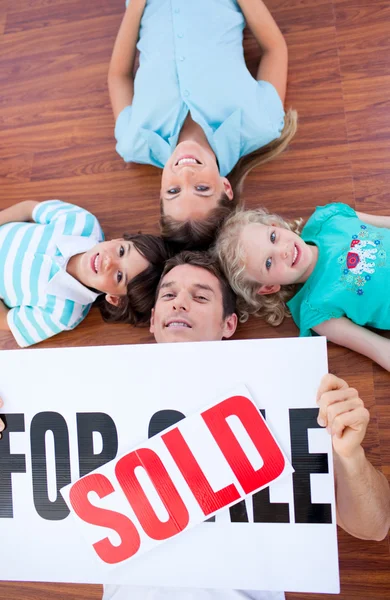 Šťastná rodina, ležící na podlaze po koupi domu — Stock fotografie