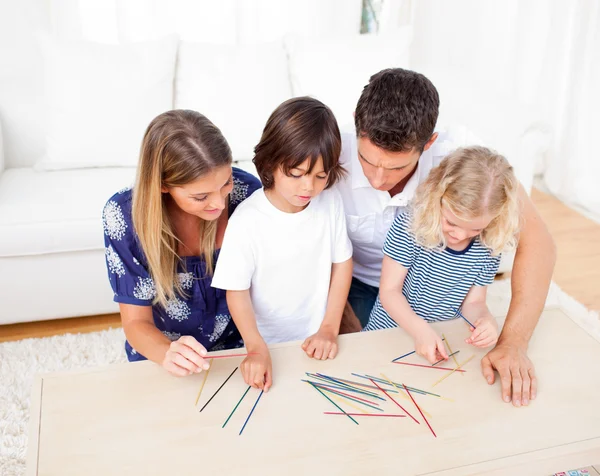 Liefdevolle familie mikado spelen in de woonkamer — Stockfoto