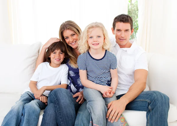 Família alegre assistindo televisão sentado no sofá — Fotografia de Stock