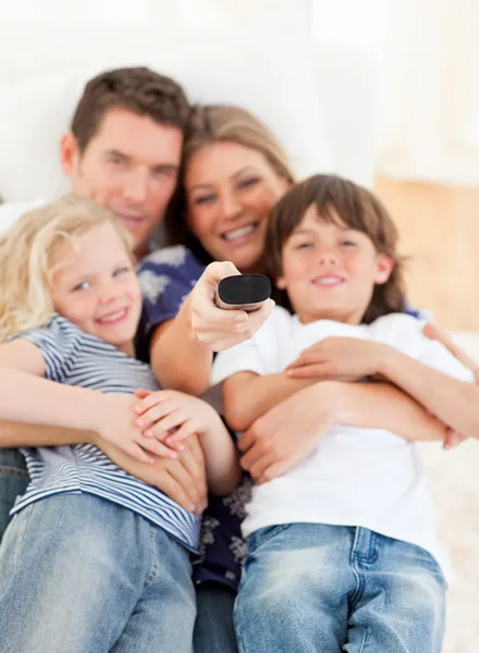 Famiglia unita che guarda la televisione seduta sul divano — Foto Stock