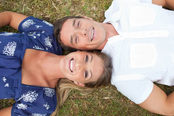 Šťastný pár ležící na trávě — Stock fotografie
