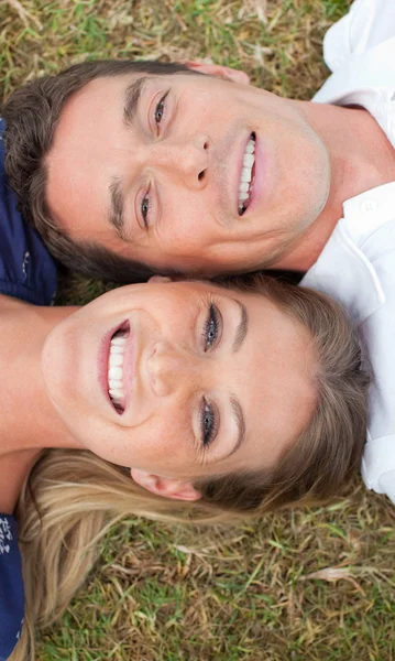 Smiling lovers lying on the grass — Stock Photo, Image