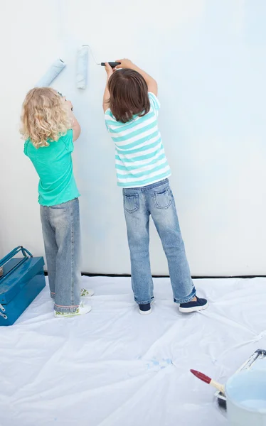 Irmãos pintando uma parede — Fotografia de Stock
