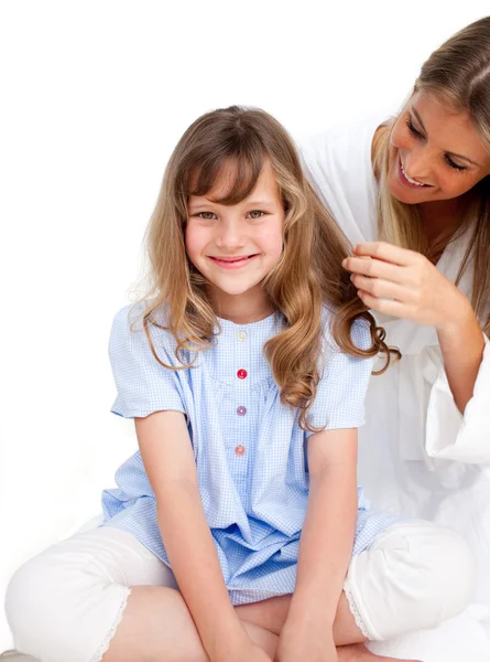 Pretty woman brushing her daugther's hair — Stock Photo, Image