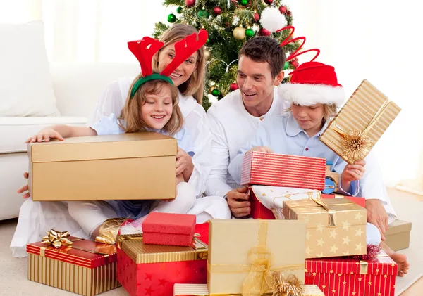 Familia joven divirtiéndose con regalos de Navidad —  Fotos de Stock