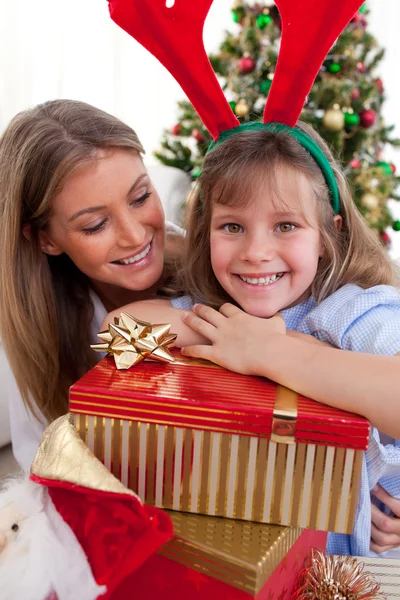 Sonriente madre y su hija sosteniendo regalos de Navidad — Foto de Stock