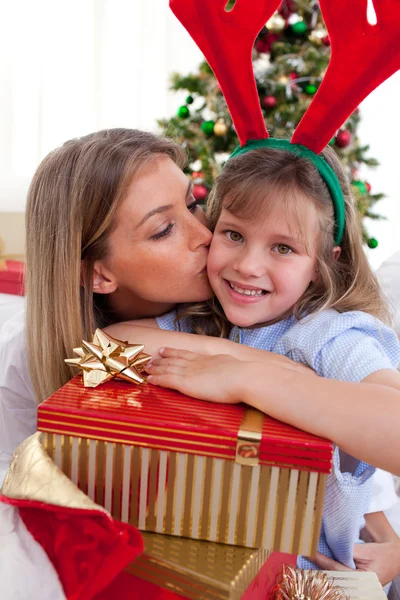 Loving mother kisses daughter at Christmas — Stock Photo, Image