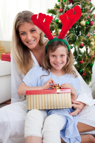 Usmíval se matka a její dcera rozbalování vánočních dárků — Stock fotografie