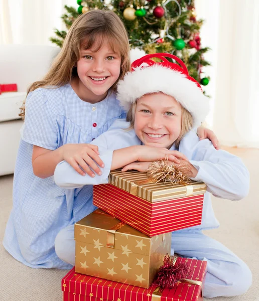 Irmãos sorridentes segurando presentes de Natal — Fotografia de Stock