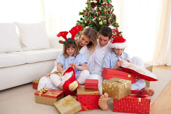 Портрет счастливой семьи, открывающей рождественские подарки — стоковое фото