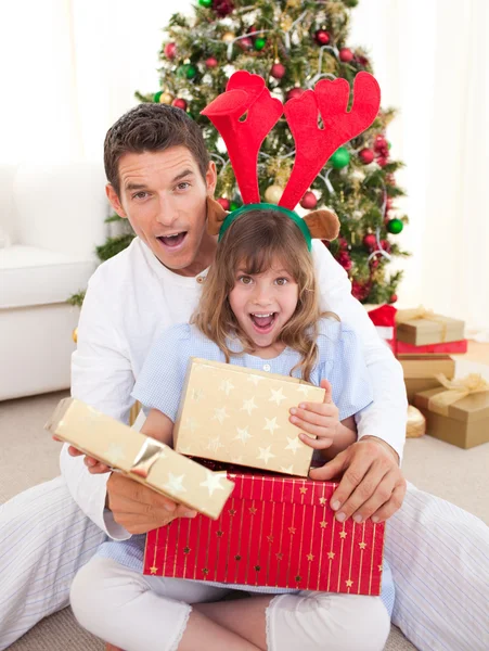 Удивлённый отец и его девушка открывают рождественские подарки — стоковое фото