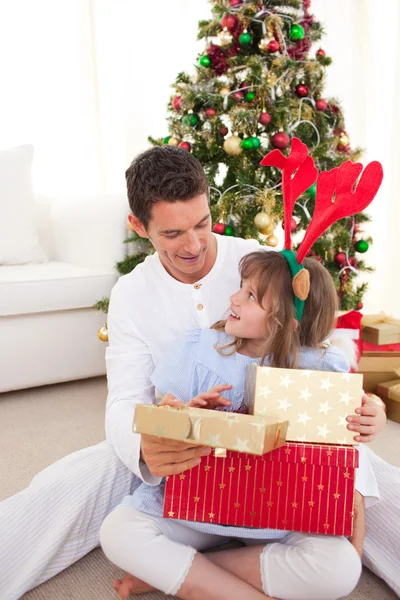 Usměvavý otec a jeho dcera otevírání vánoční dárky — Stock fotografie
