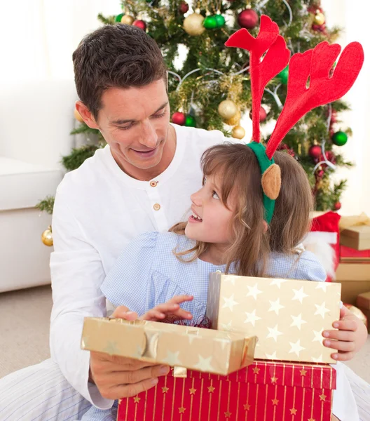 Retrato de um pai sorridente e sua filha abrindo o Natal — Fotografia de Stock