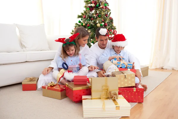 Ung familj uppackning julklappar — Stockfoto