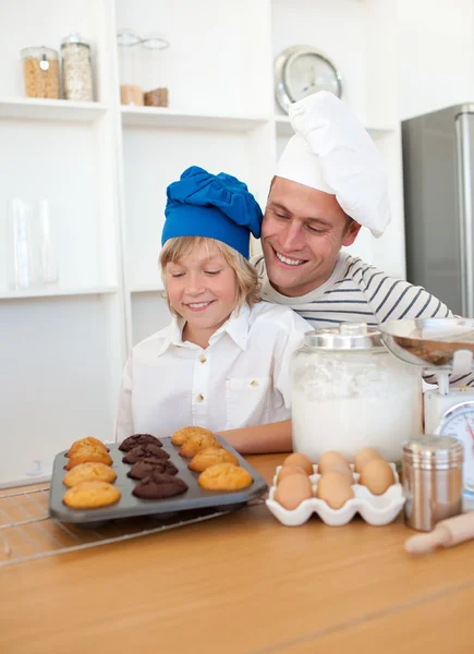 Pai encantador e seu filho apresentando seus muffins — Fotografia de Stock