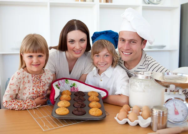 Cheerful family presenting their muffins — Stock Photo, Image