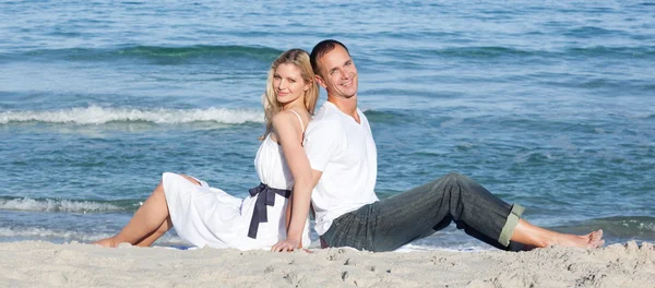 Retrato de pareja sentada en la arena — Foto de Stock