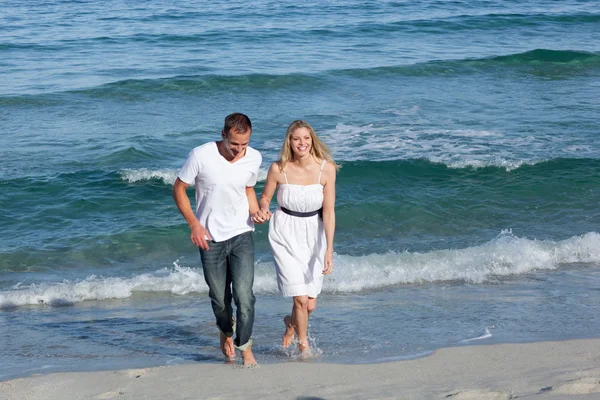 Amantes cariñosos caminando a la orilla del mar —  Fotos de Stock