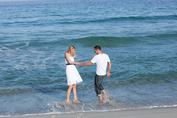Amantes alegres divirtiéndose en la playa — Foto de Stock