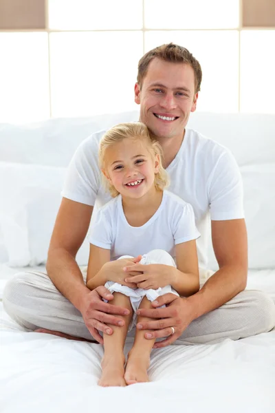 Caring father with his little girl sitting on bed — Stock Photo, Image