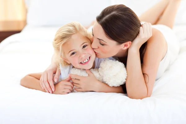 Attractive mother kissing her little girl — Stock Photo, Image