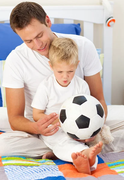 Menino loiro e seu pai brincando com uma bola de futebol — Fotografia de Stock
