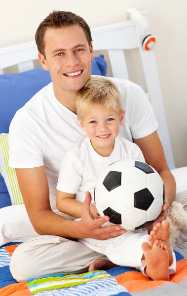 Close-up of a little boy and his father playing with a soccer ba — Stock Photo, Image