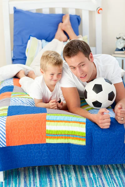 Bonito pai e seu filho brincando com uma bola de futebol — Fotografia de Stock