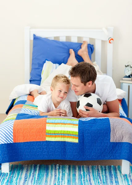 Atractivo padre y su hijo jugando con una pelota de fútbol — Foto de Stock