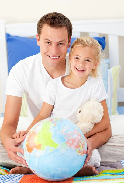 Внимательный отец и его дочь смотрят на земной шар — стоковое фото