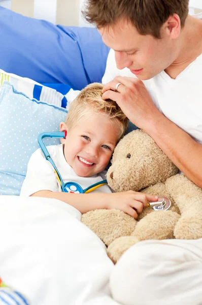 Usmívající se otec a syn nemocný, hraje se stetoskopem — Stock fotografie