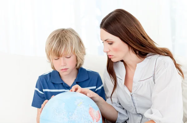 Gebannt blickt das Kind mit seiner Mutter auf eine Erdkugel — Stockfoto