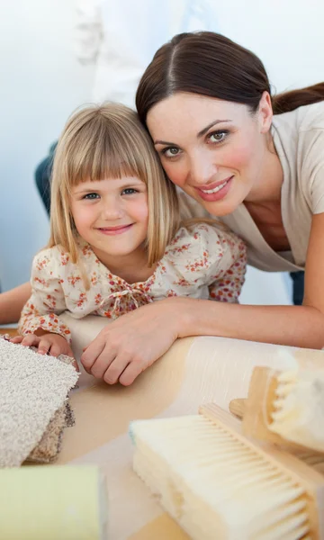 Lachende moeder en haar dochter decoreren een kamer — Stockfoto